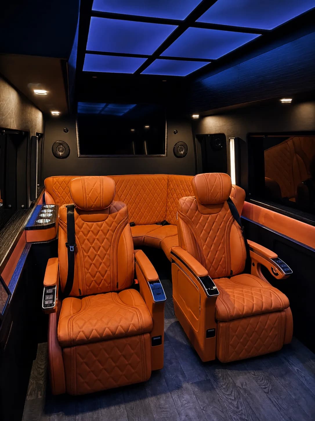 Jet Sprinter cabin with orange executive seating and blue ambient ceiling lighting