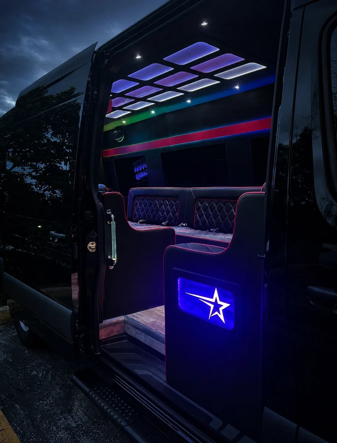 Party Limo Sprinter cabin visible through the open side door with illuminated ceiling panels